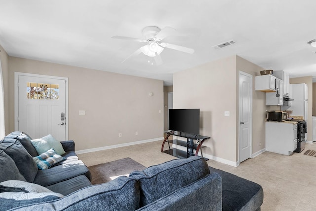 living room with visible vents, baseboards, and ceiling fan