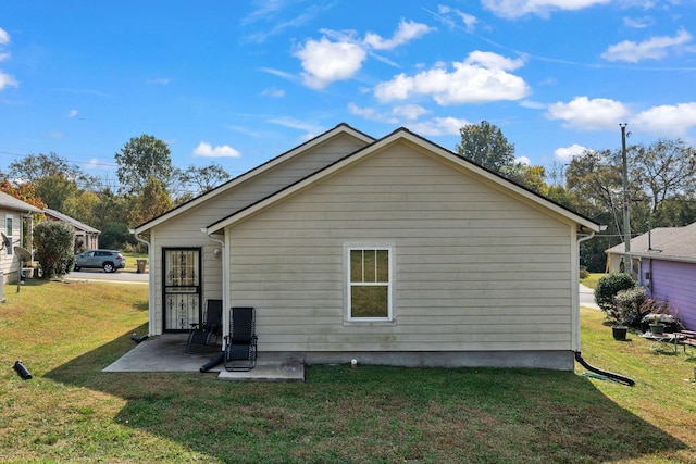 rear view of property with a lawn and a patio area