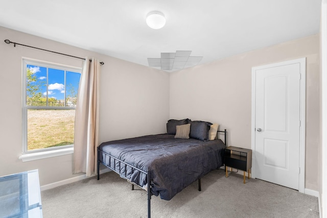 bedroom with light carpet and baseboards