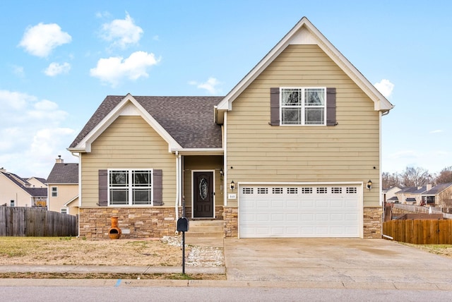 view of front of property with an attached garage, stone siding, concrete driveway, and fence