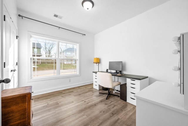 office area featuring light wood-style floors, baseboards, and visible vents