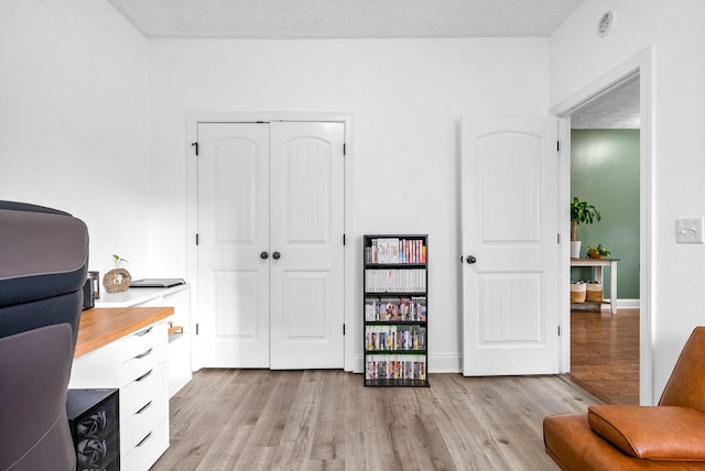 home office with light wood-type flooring and baseboards