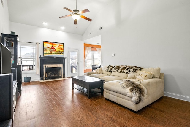 living room featuring plenty of natural light, high vaulted ceiling, hardwood / wood-style floors, and a high end fireplace