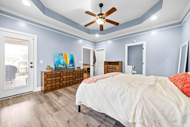 bedroom with baseboards, ceiling fan, ornamental molding, wood finished floors, and a tray ceiling