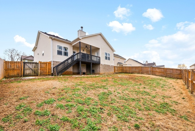 rear view of property with a fenced backyard, a ceiling fan, stairs, a yard, and a chimney