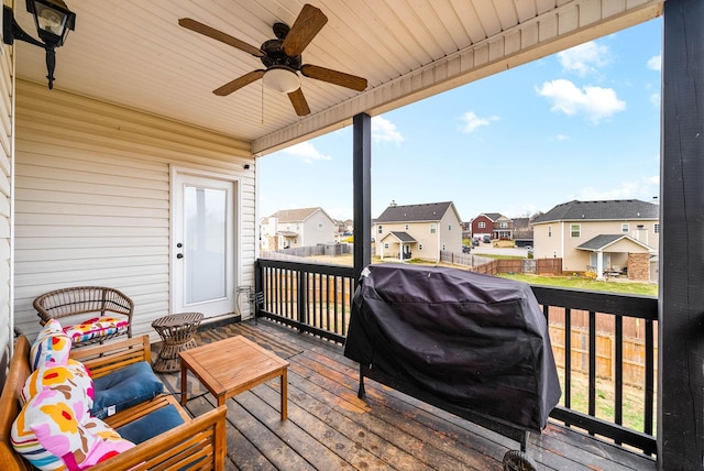 wooden terrace with ceiling fan, a residential view, fence, and area for grilling