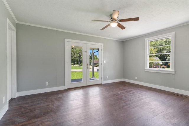 empty room featuring visible vents, dark wood-style flooring, a wealth of natural light, and ornamental molding