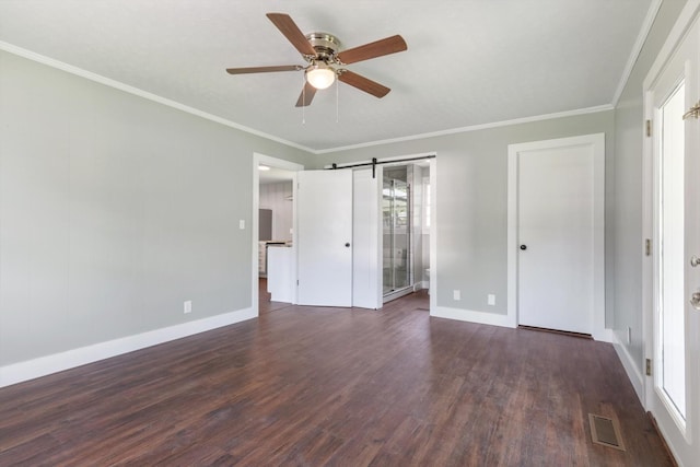 unfurnished bedroom with a barn door, visible vents, dark wood-style flooring, and ornamental molding