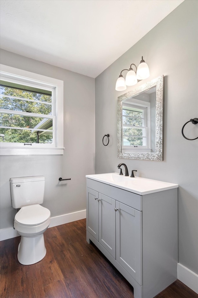 bathroom with vanity, wood finished floors, toilet, and baseboards