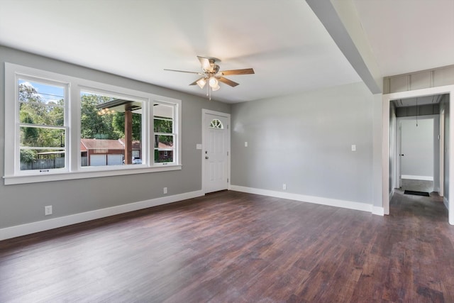 interior space with attic access, baseboards, dark wood finished floors, and a ceiling fan