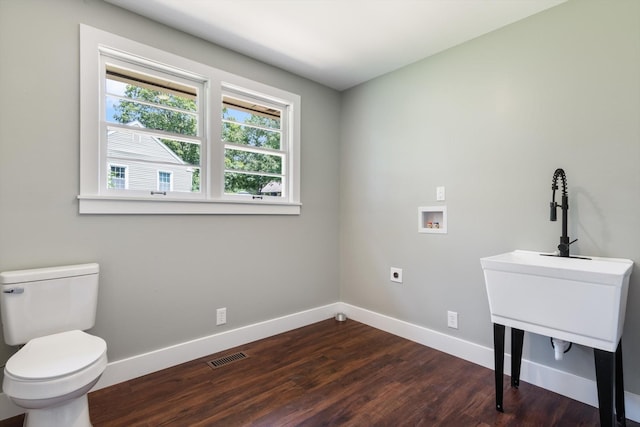 laundry room with laundry area, washer hookup, visible vents, baseboards, and dark wood finished floors