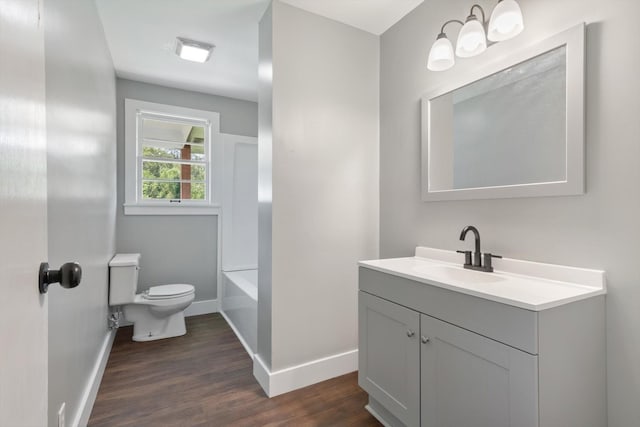 full bath with toilet, wood finished floors, vanity, and baseboards