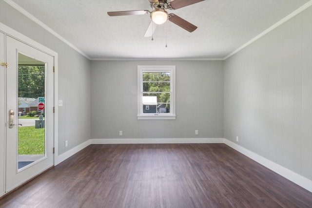 empty room featuring baseboards, dark wood-type flooring, and crown molding