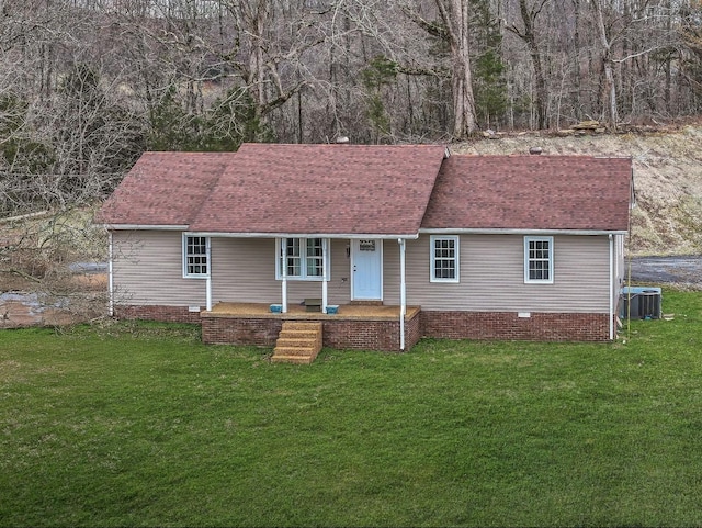 single story home with a porch, roof with shingles, a front lawn, and central AC unit