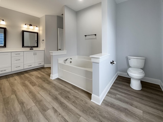 full bathroom with a garden tub, baseboards, wood finished floors, and vanity