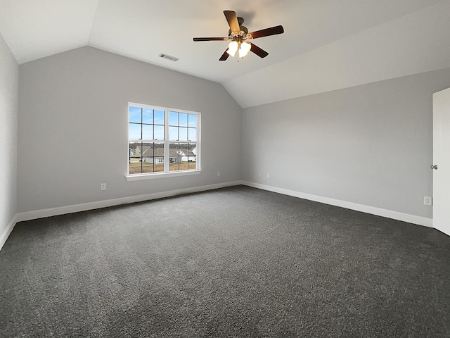 spare room with lofted ceiling, baseboards, visible vents, and dark carpet