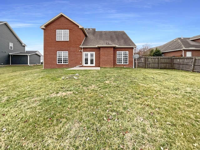 back of property featuring french doors, brick siding, a lawn, and fence