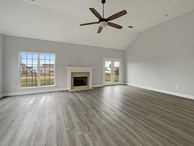 unfurnished living room with vaulted ceiling, light wood finished floors, a fireplace with flush hearth, and baseboards