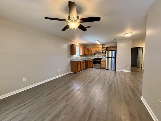 kitchen featuring stainless steel appliances, a sink, visible vents, baseboards, and open shelves