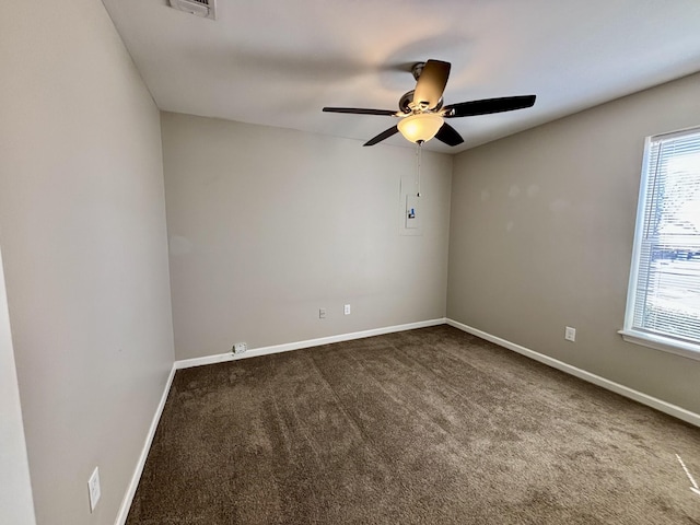 carpeted spare room featuring visible vents, ceiling fan, and baseboards