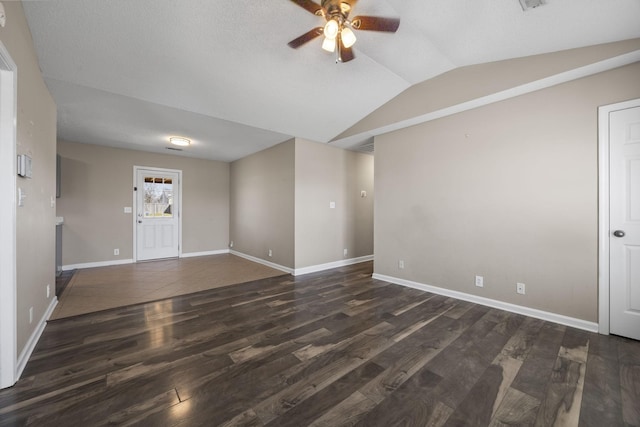 spare room with baseboards, a ceiling fan, vaulted ceiling, and dark wood finished floors