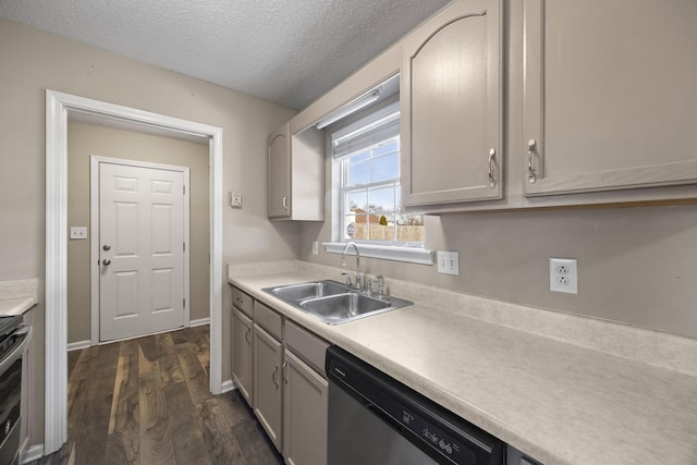 kitchen featuring a textured ceiling, dark wood-type flooring, a sink, light countertops, and appliances with stainless steel finishes