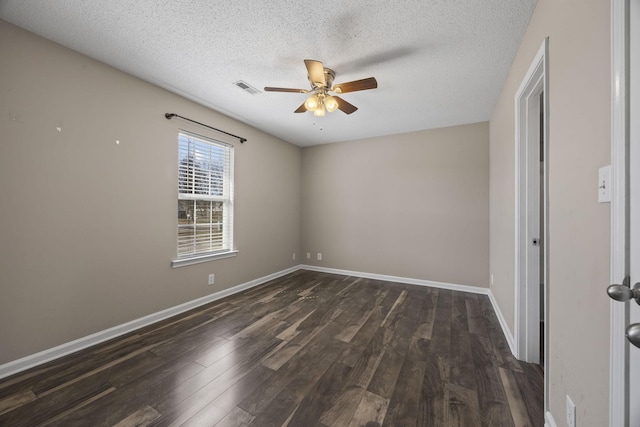 unfurnished room with dark wood-style floors, visible vents, baseboards, and a ceiling fan