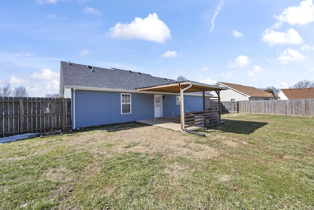 rear view of house featuring a patio area, a fenced backyard, a yard, and roof with shingles