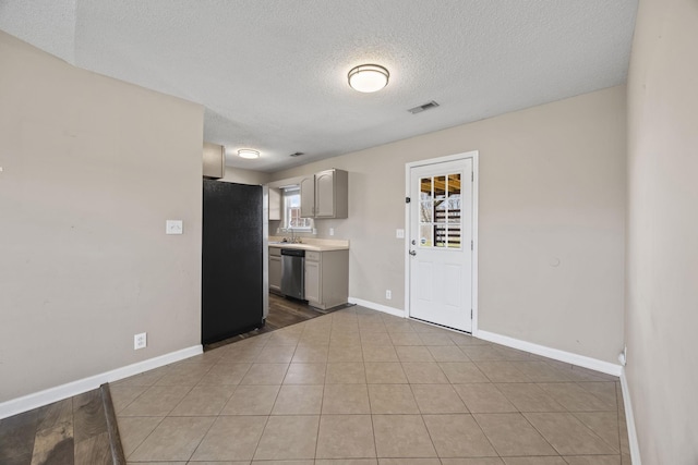 kitchen with baseboards, appliances with stainless steel finishes, light countertops, and gray cabinetry