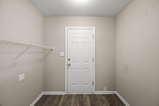 washroom featuring a textured ceiling, baseboards, and dark wood-type flooring