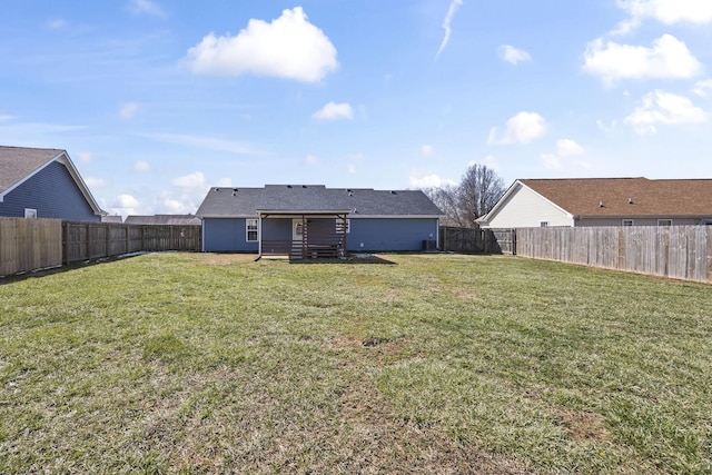 back of house featuring a lawn and a fenced backyard