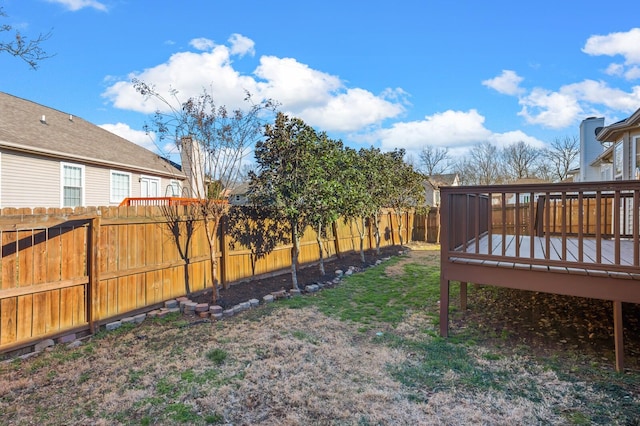 view of yard with a fenced backyard and a wooden deck