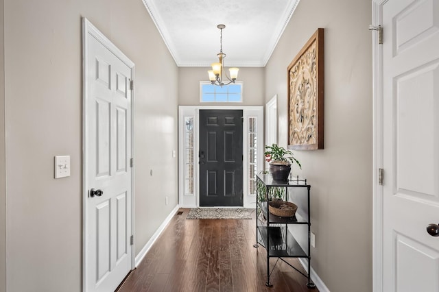 foyer featuring dark wood-style floors, baseboards, ornamental molding, and a chandelier