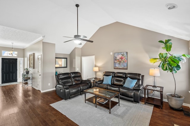 living room featuring lofted ceiling, ceiling fan with notable chandelier, wood finished floors, baseboards, and ornamental molding