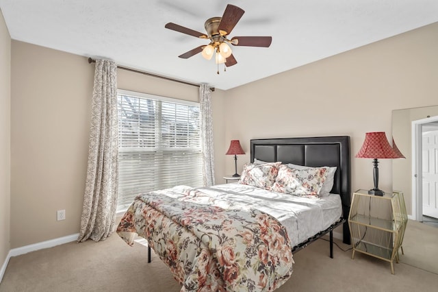 carpeted bedroom with ceiling fan and baseboards