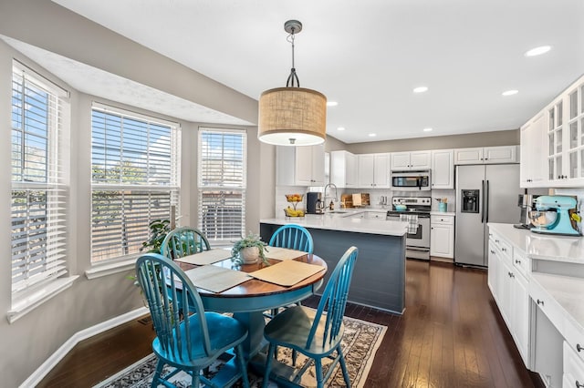 dining room with baseboards, dark wood finished floors, and recessed lighting