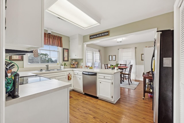 kitchen featuring a peninsula, appliances with stainless steel finishes, light countertops, and white cabinets