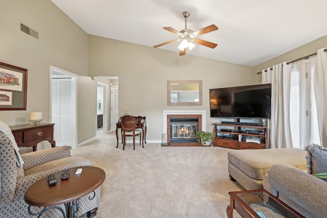 living room featuring visible vents, vaulted ceiling, a tiled fireplace, and light colored carpet