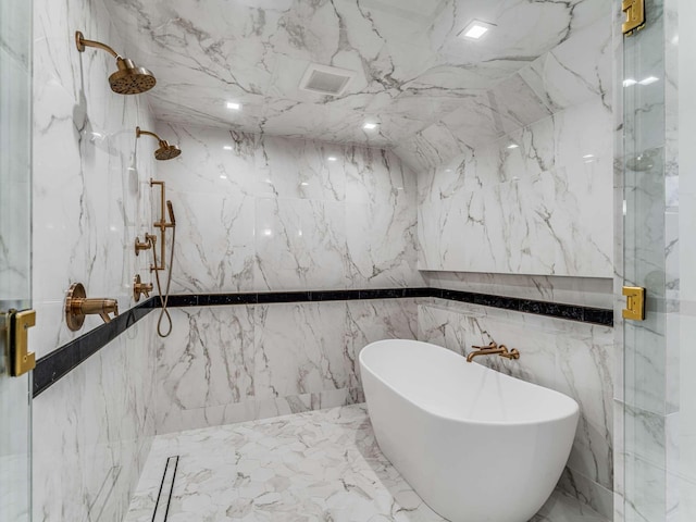 bathroom featuring a freestanding tub and stone wall