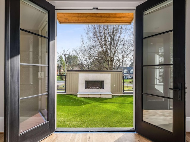 entryway with an outdoor fireplace and wood finished floors