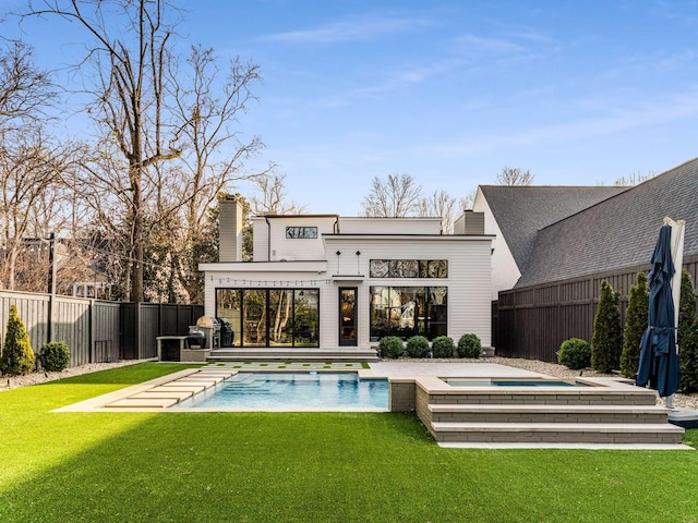 back of house with a fenced backyard, a fenced in pool, and a yard