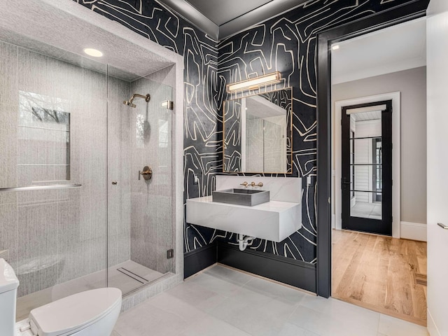 full bath featuring baseboards, a stall shower, toilet, and wallpapered walls