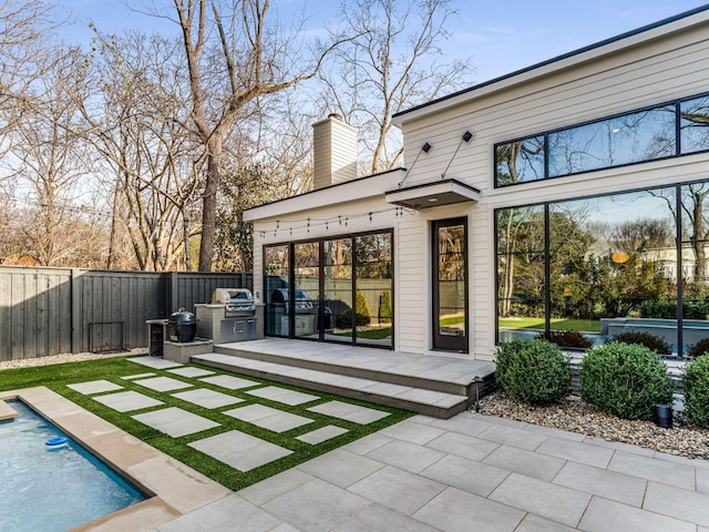 rear view of property featuring a patio area, a fenced backyard, a chimney, and a fenced in pool