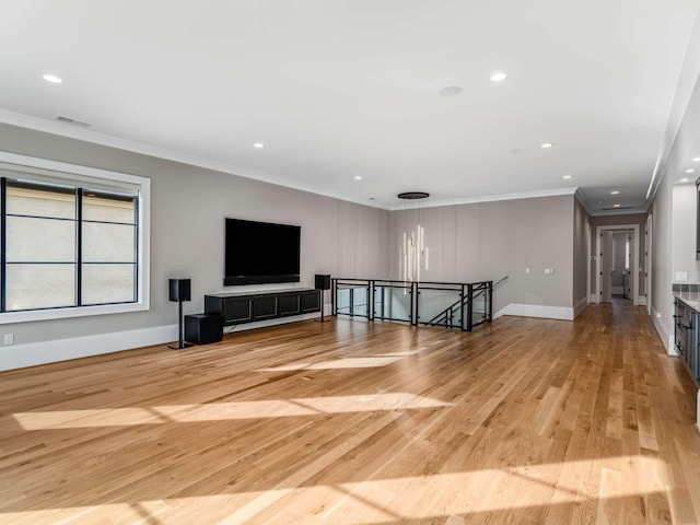 unfurnished living room with crown molding, recessed lighting, visible vents, light wood-type flooring, and baseboards