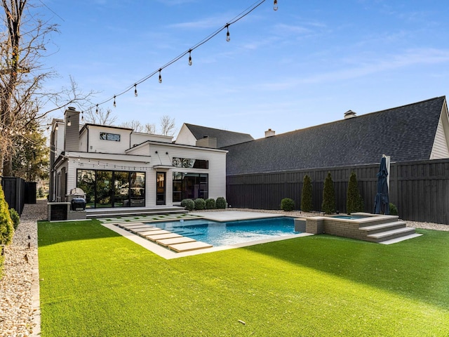 rear view of property with a yard, a patio, a chimney, and a fenced backyard