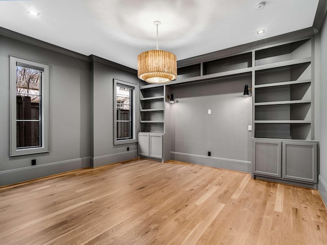 interior space featuring built in features, light wood-type flooring, plenty of natural light, and baseboards