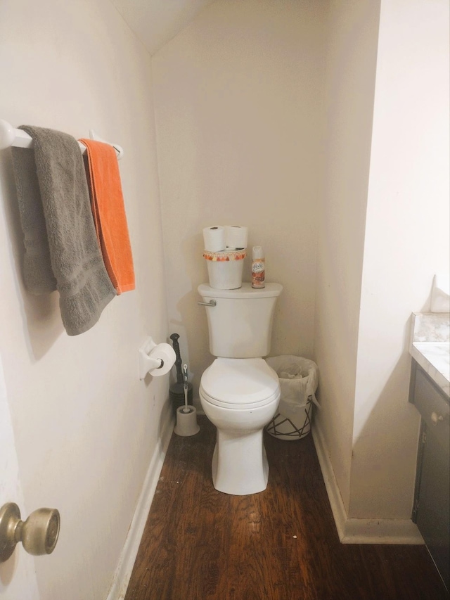 bathroom featuring baseboards, vanity, toilet, and wood finished floors