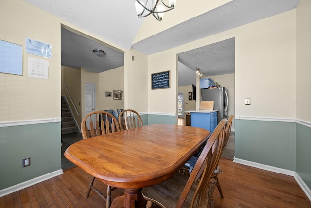 dining space featuring stairs, dark wood-style flooring, a textured ceiling, and baseboards