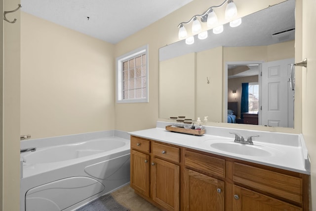 full bathroom with a healthy amount of sunlight, a garden tub, vanity, and ensuite bath