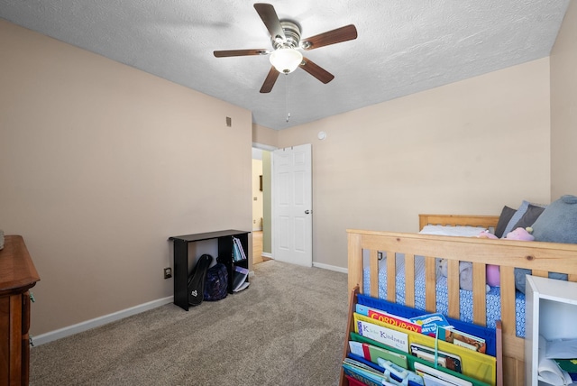 bedroom featuring a ceiling fan, carpet, baseboards, and a textured ceiling